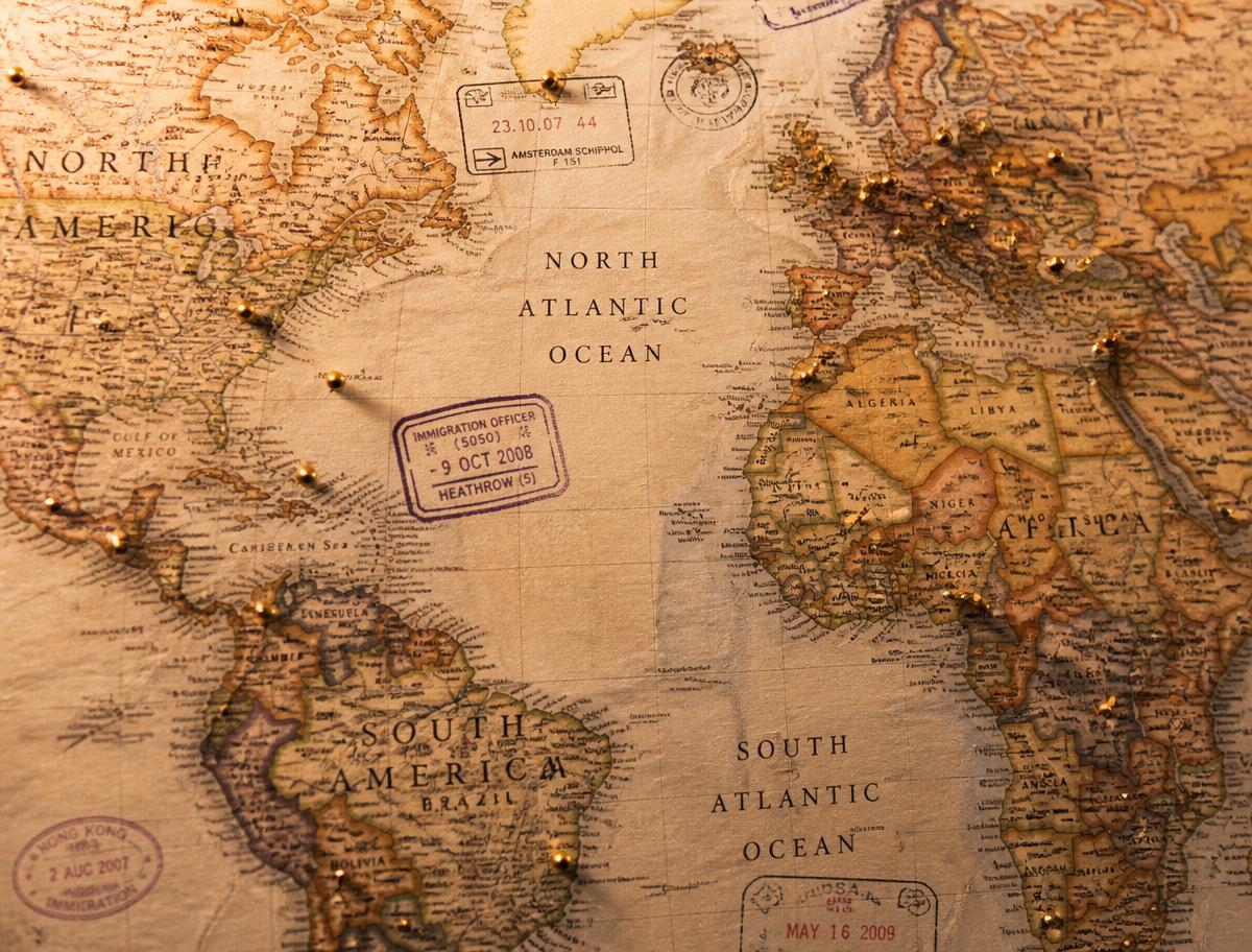 Antique world map with gold pins and passport stamps